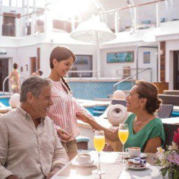 A Group Meets on the Deck by the Pool for Mimosas at The Haven by Norwegian